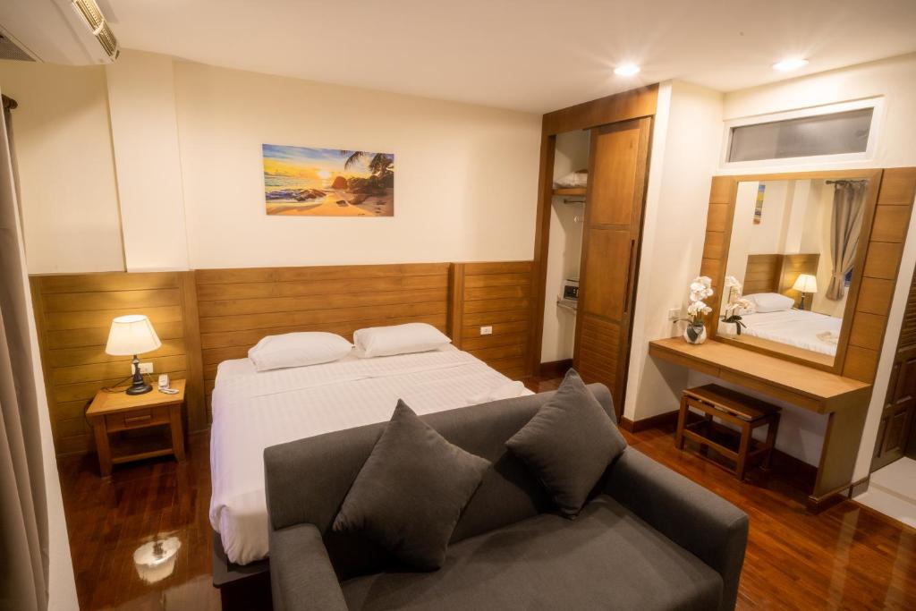 a hotel room with a bed and a couch at Baan Chuan Chom Pattaya in Pattaya Central