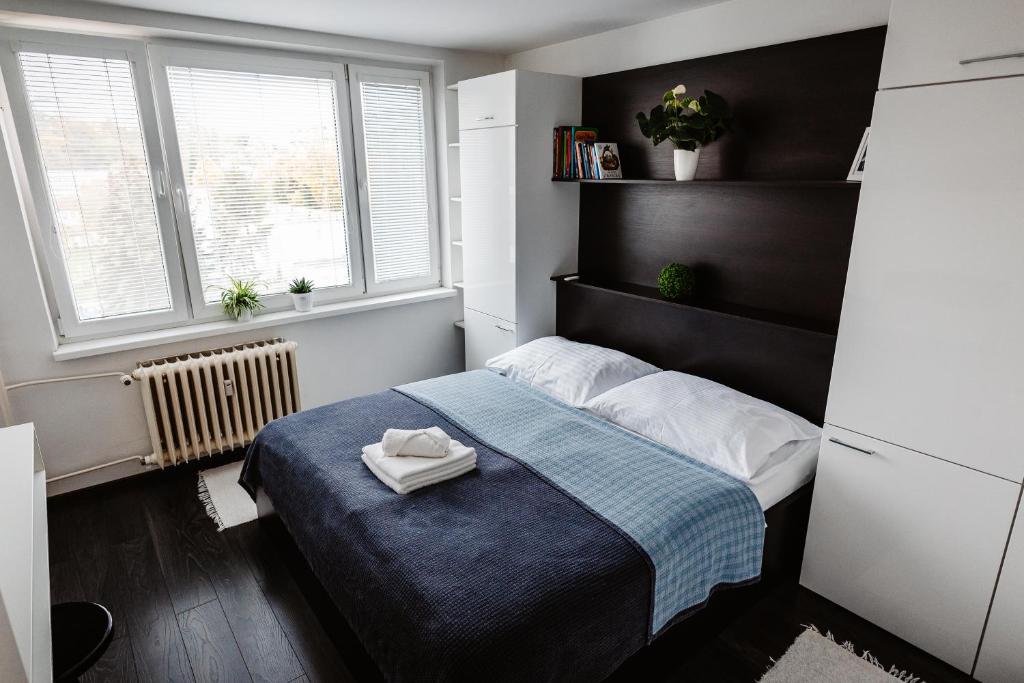 niewielka sypialnia z łóżkiem i 2 oknami w obiekcie AH Kuzmányho w Koszycach