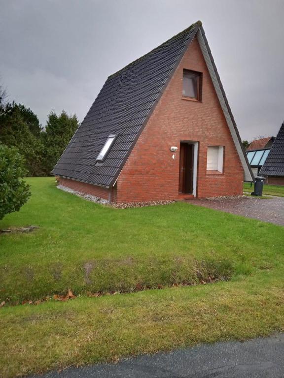 a red brick house with a black roof at Ferienhaus Yanic in Neuharlingersiel