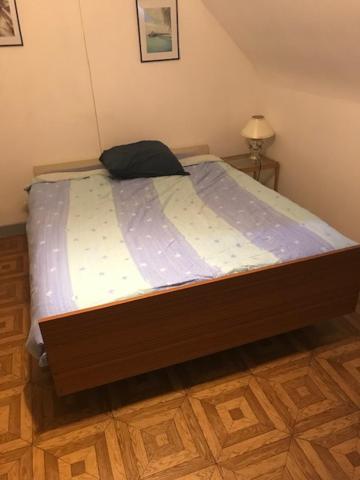 CHAMBRE D 'HOTE في Harnes: سرير في غرفة نوم مع أرضية خشبية