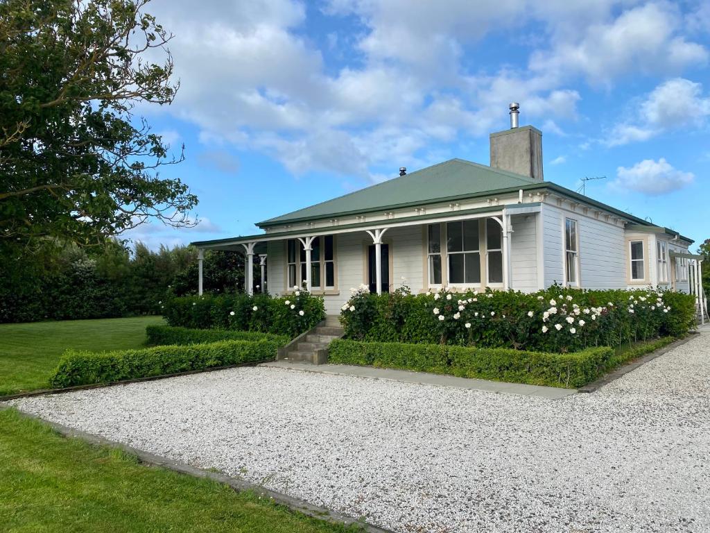 a white house with white flowers in front of it at Botham's Beauty - Blenheim Holiday Home in Blenheim