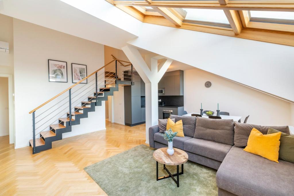 ein Wohnzimmer mit einem Sofa und einer Treppe in der Unterkunft Petrin Tower Residence in Prag
