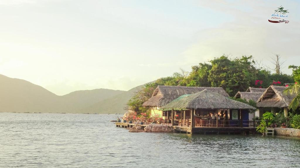 a group of houses on a dock in the water at Whale Island Resort in Dam Mon