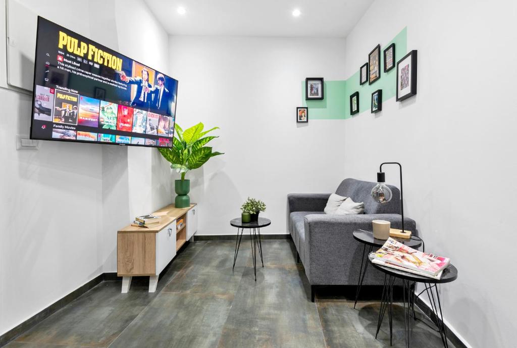 a living room with a couch and a flat screen tv at Lively new apt with Bomb Shelter beside the beach M5 in Tel Aviv