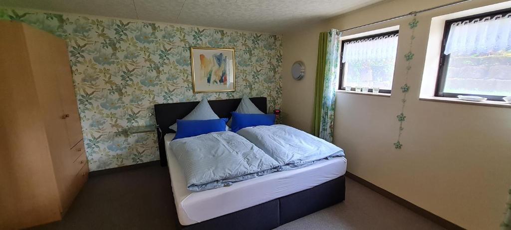 1 dormitorio con 1 cama con almohadas azules en Ferienwohnung Sächsische Schweiz Kurort Rathen en Kurort Rathen