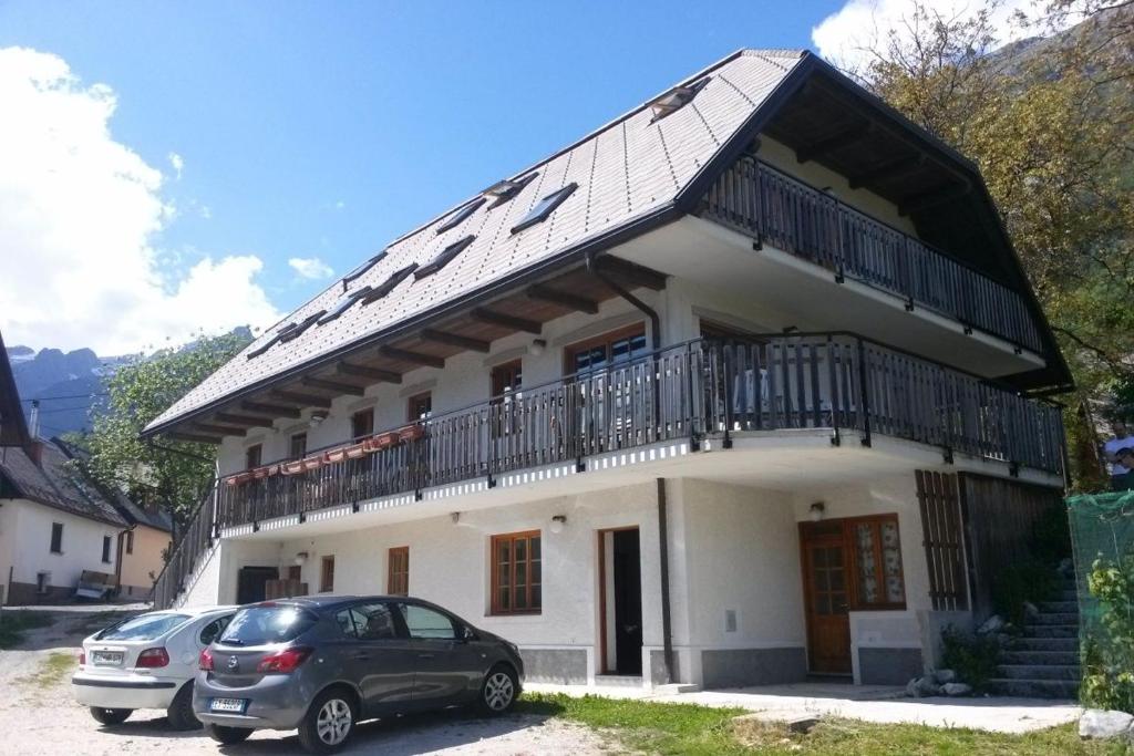 a house with two cars parked in front of it at Mala Vas Chalet in Bovec