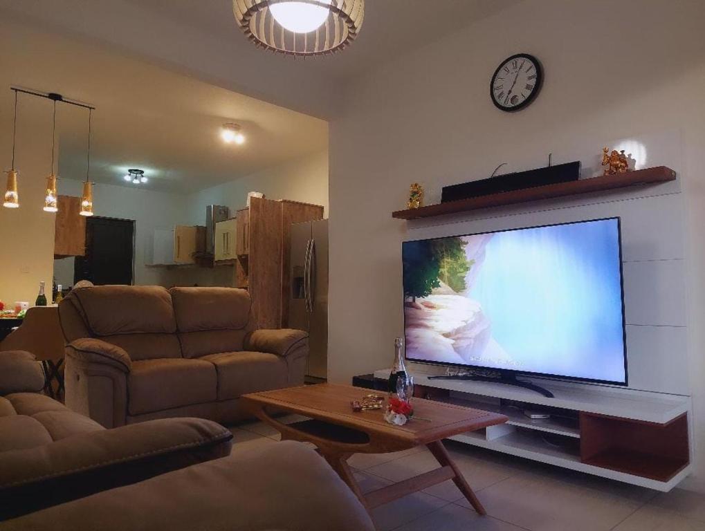 WESTWOOD - DELUXE 03 BEDROOM APPARTMENT - POOL, near BEACH في فليك-إن-فلاك: غرفة معيشة مع تلفزيون بشاشة مسطحة كبيرة