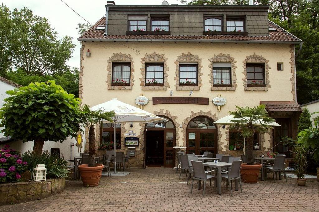 ein Restaurant mit Tischen und Stühlen vor einem Gebäude in der Unterkunft Hotel zur Klause in Saarbrücken