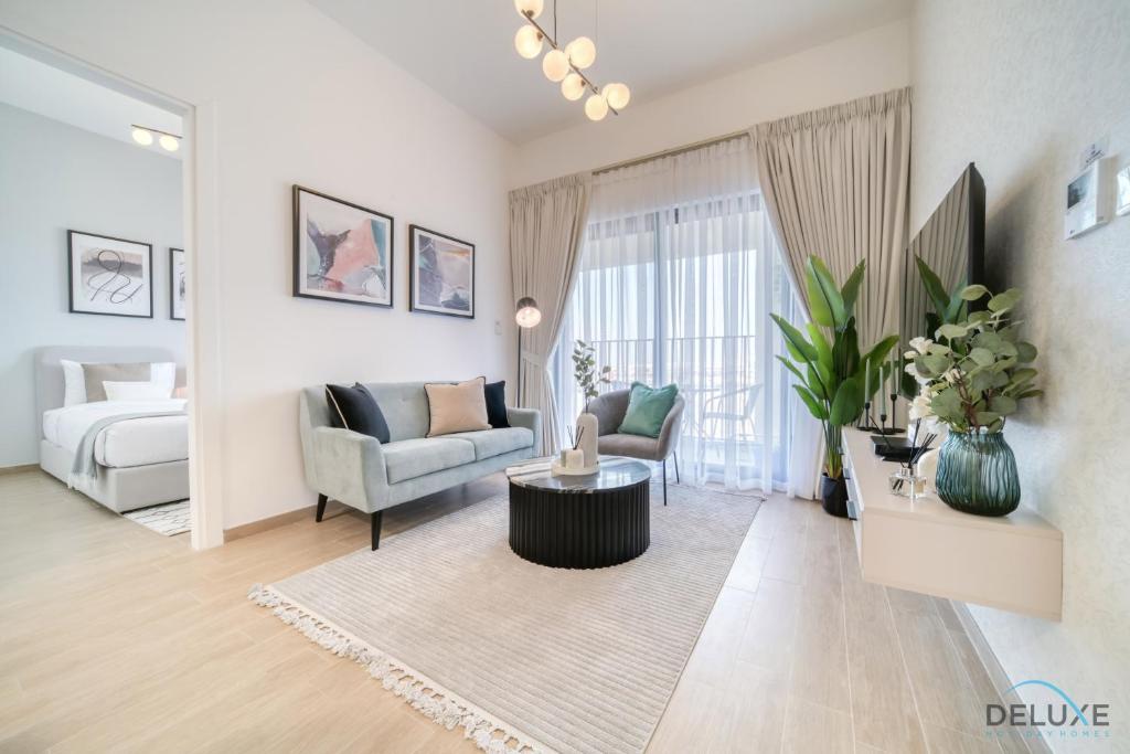 a living room with a couch and a table at Serene 2BR at The Nook Wasl Gate Jebel Ali by Deluxe Holiday Homes in Dubai