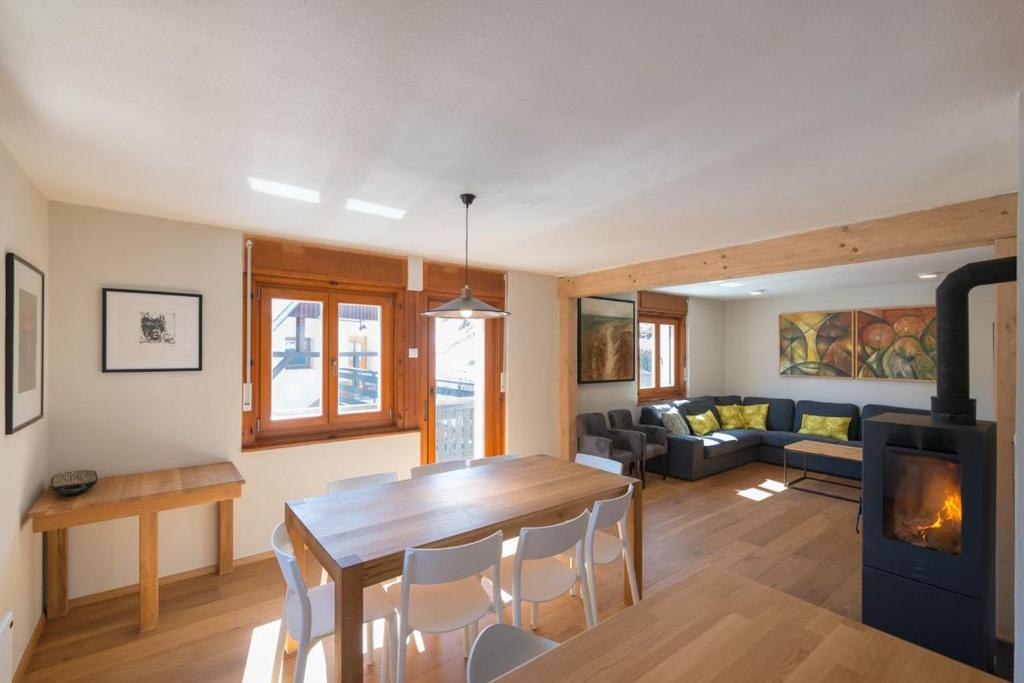 a living room with a table and a fireplace at Mostnica Cottage in Bohinj