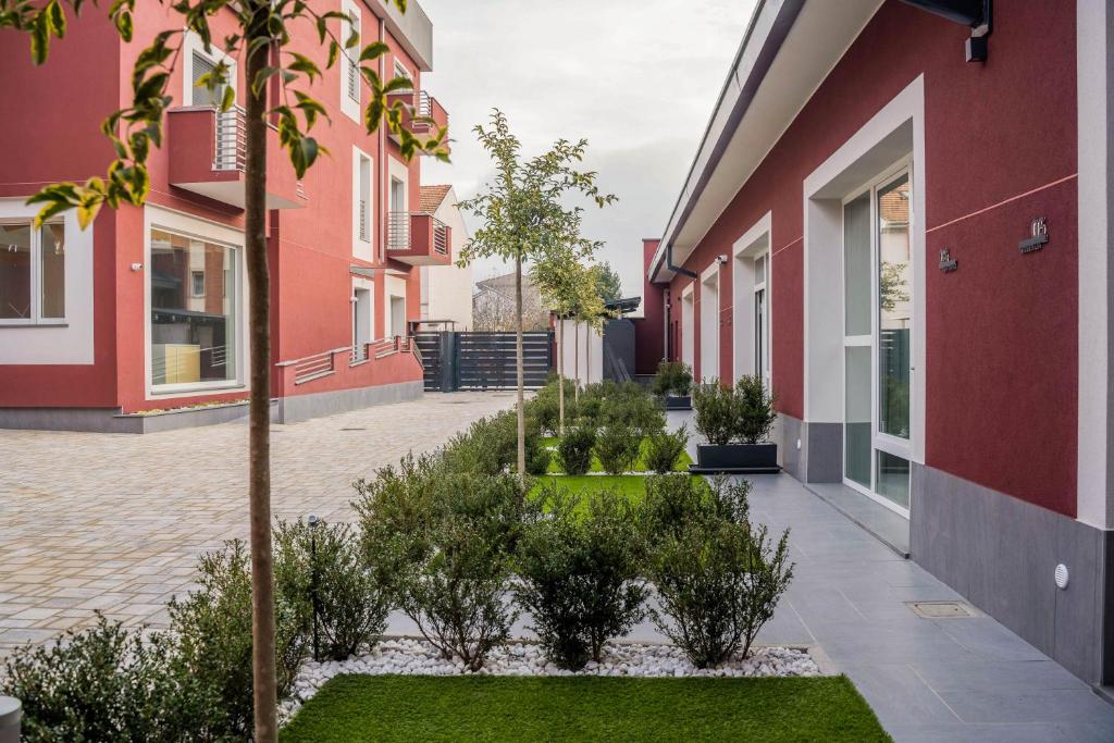 une cour d'un bâtiment avec des arbres et des plantes dans l'établissement Terranova49, à Novara