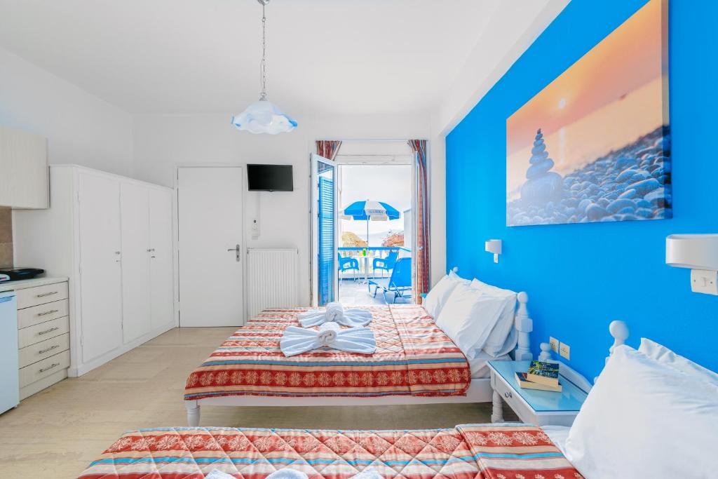een slaapkamer met een bed en een blauwe muur bij Villa George in Batsi