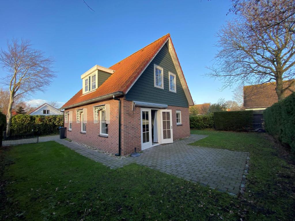 een stenen huis met een rood dak bij Camping de Brem in Renesse