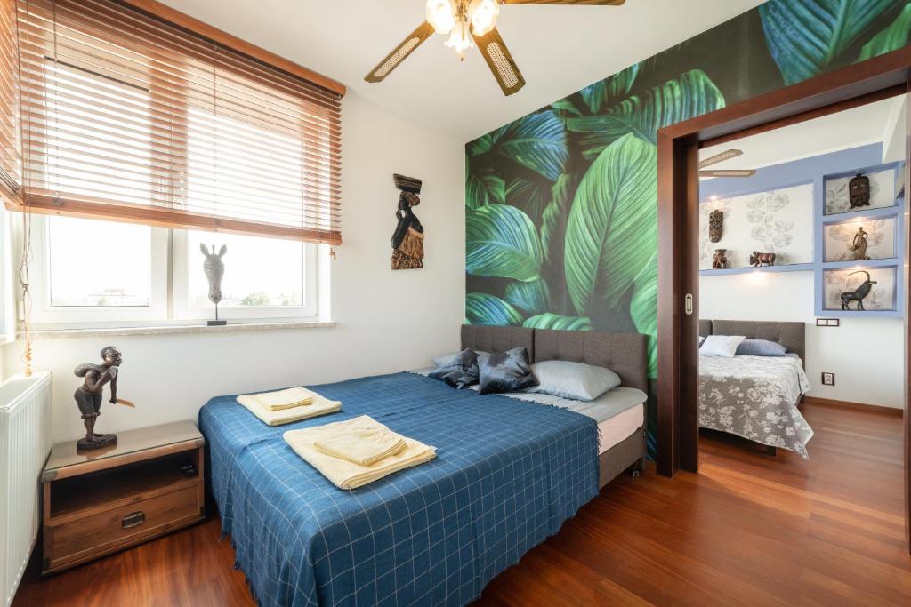 un dormitorio con una cama azul con un gato sobre ella en Afrika, en Władysławowo