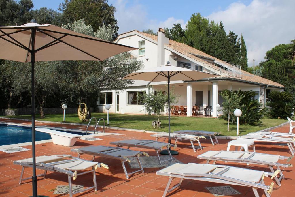 a group of chairs and umbrellas next to a pool at Villa D&D in Cava deʼ Tirreni