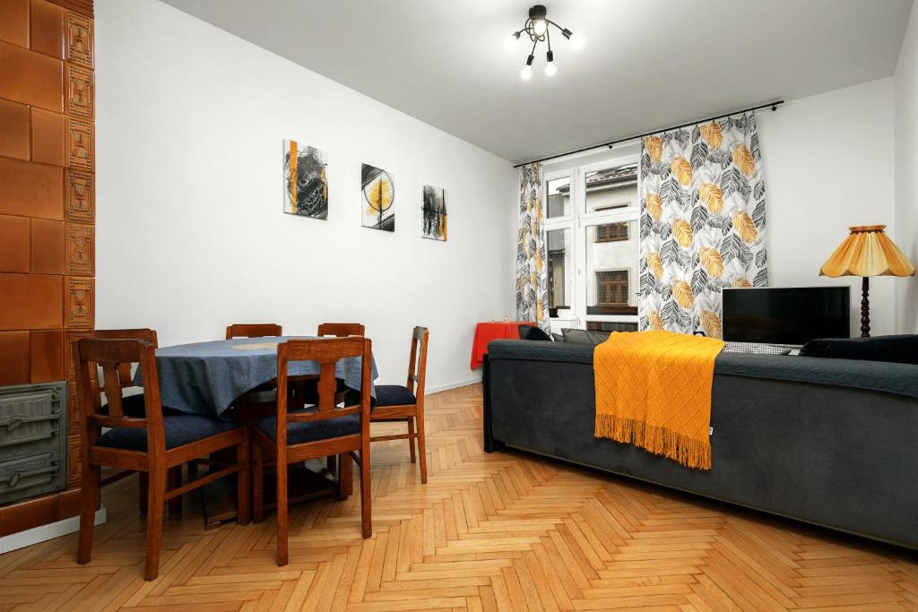 a living room with a table and a couch at Apartament blisko Wawelu in Kraków
