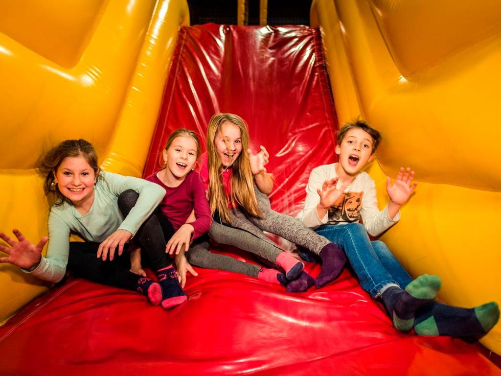 three girls are sitting on a inflatable slide at Landal Marina Lipno in Lipno nad Vltavou