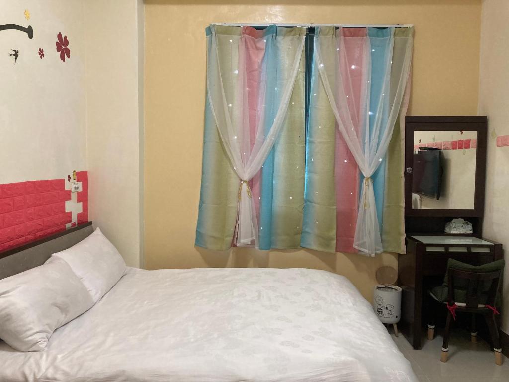 a bedroom with a bed and a window with curtains at Guanshan Fukuda Homestay in Guanshan