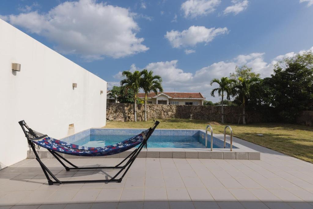 a hammock in a chair next to a swimming pool at ritomaru villa pierce miyakojima in Miyako Island