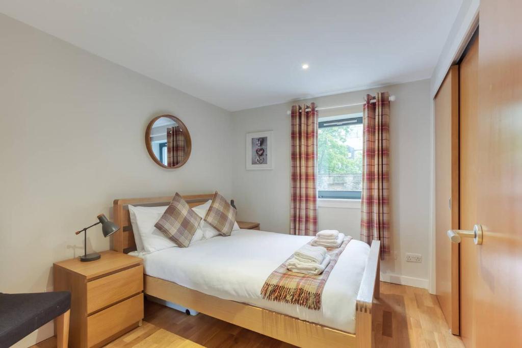 a bedroom with a bed and a window at *Amazing Location!*In heart of the City. 2BR & Cot in Edinburgh