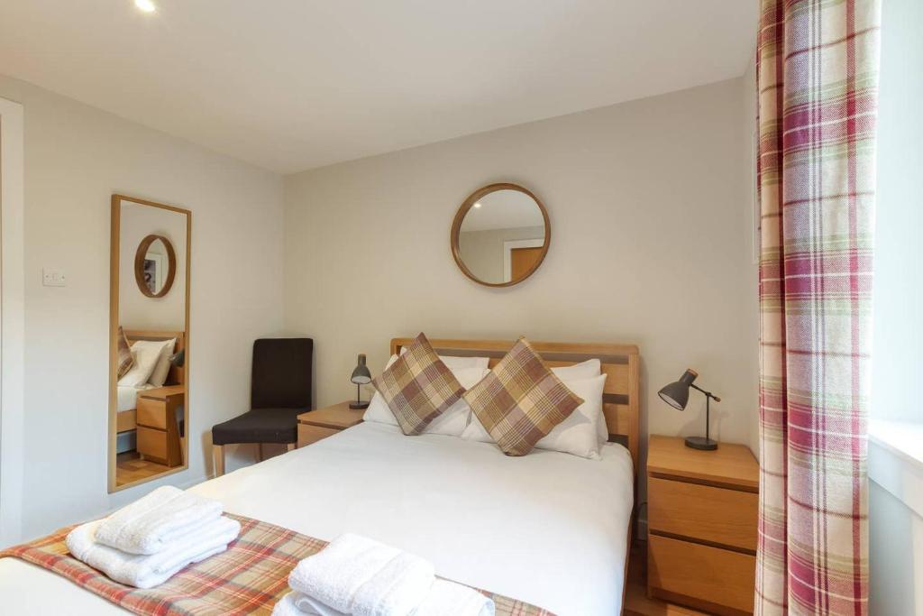 a bedroom with a white bed and a mirror at *Amazing Location!*In heart of the City. 2BR & Cot in Edinburgh