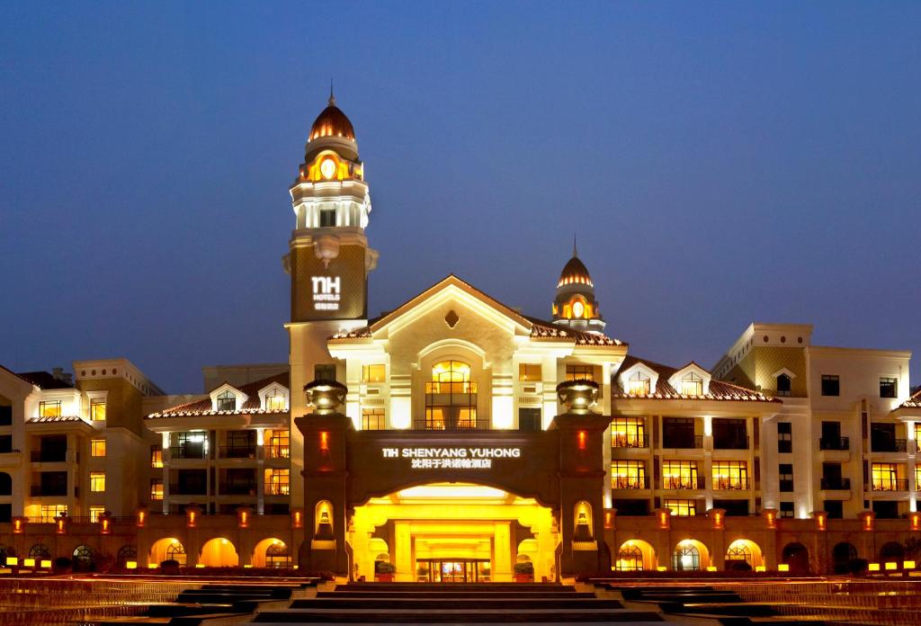 瀋陽的住宿－沈阳诺翰酒店，一座在晚上设有钟楼的大型建筑