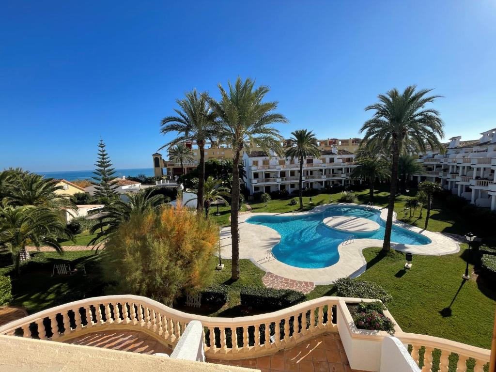 - une vue sur un complexe avec une piscine et des palmiers dans l'établissement Denia Blau-Serviden, à Dénia