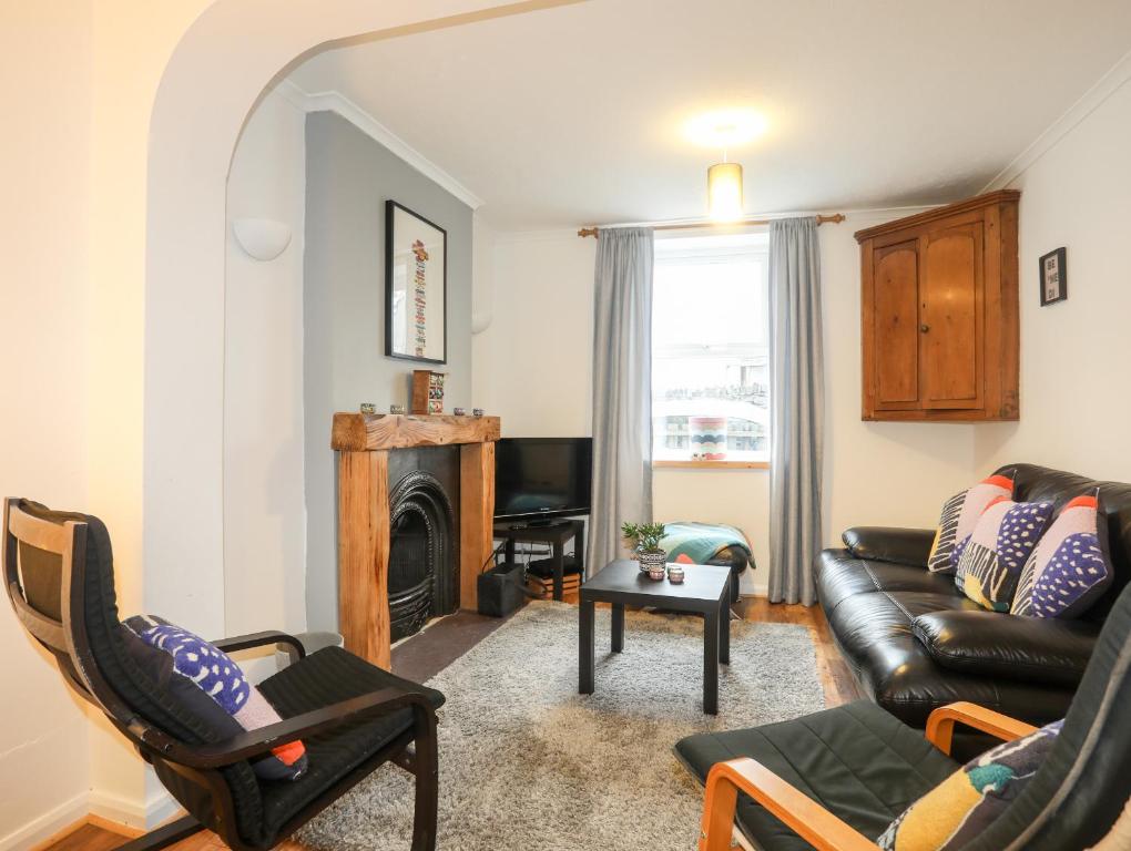 a living room with a couch and a fireplace at 5 Thomas Street in Llanberis