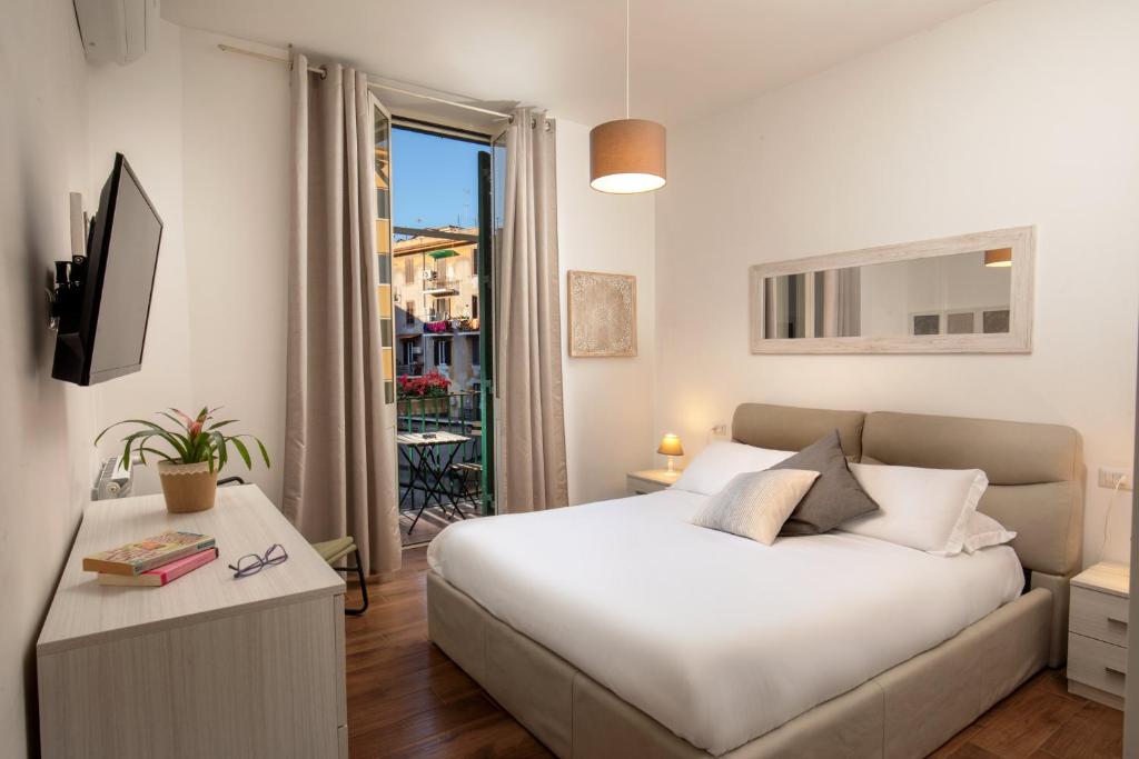 a bedroom with a white bed and a balcony at Fornaci Vatican Flat in Rome