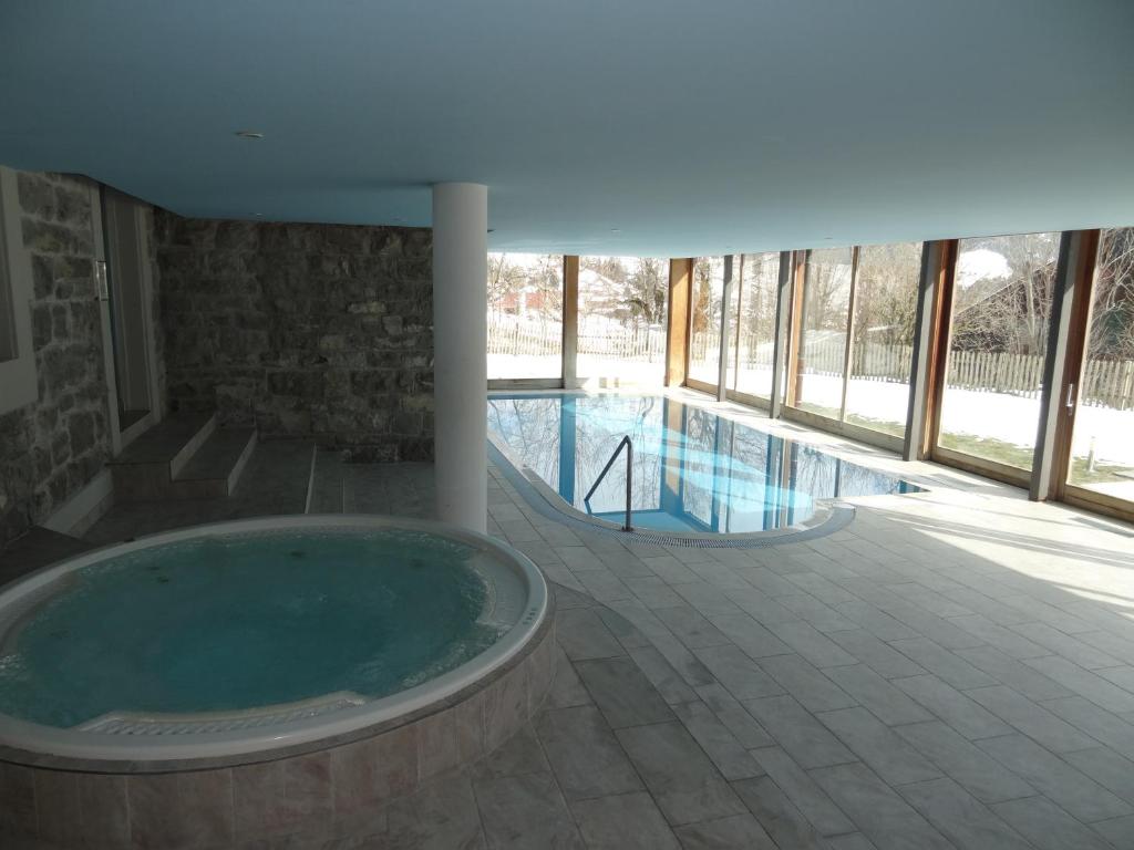 a large tub in a house with a swimming pool at Luxury Apartment, Panoramic Mountain Views, 5* Spa Facilities - 4 Bedroom in Chateau-d'Oex