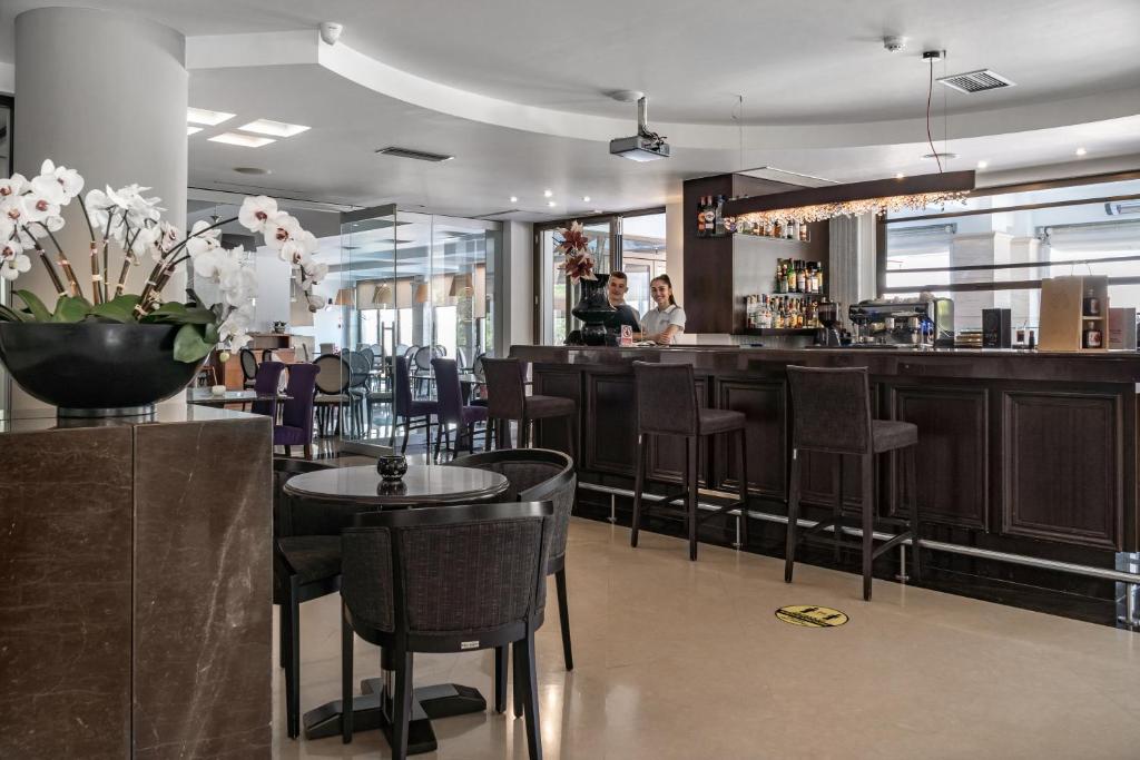a restaurant with tables and chairs and a bar at Danai Hotel & Spa in Olympic Beach