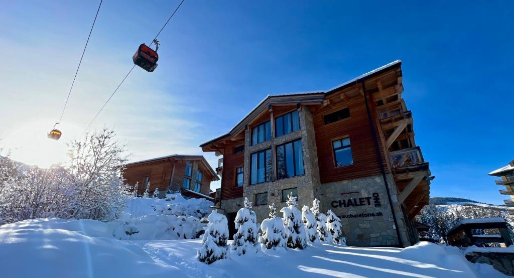 a cabin in the snow with a ski lift at Chalet One Jasná in Demanovska Dolina