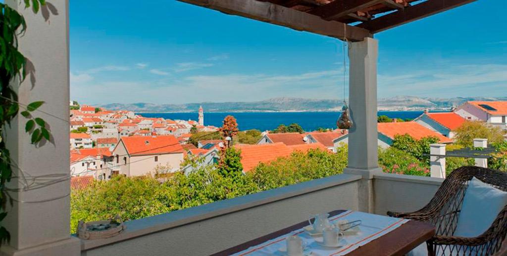 een balkon met een tafel en uitzicht op de stad bij Villa Lorena in Sutivan