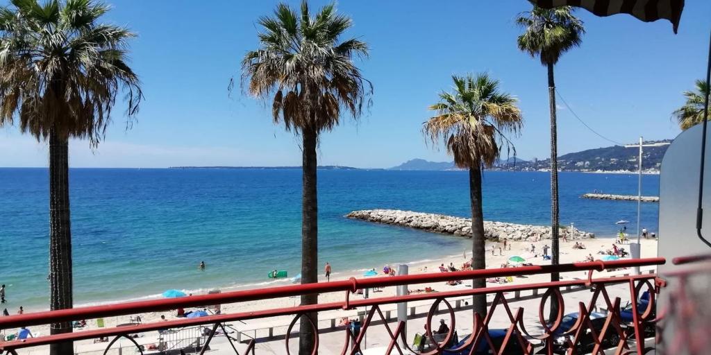 a view of a beach with palm trees and the ocean at LE CONSTELLATION AP4333 By Riviera Holiday Homes in Juan-les-Pins