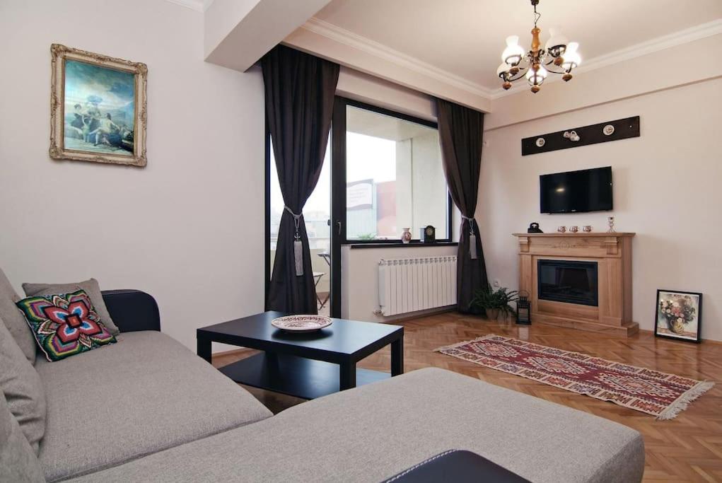 uma sala de estar com um sofá e uma mesa em Istoric Center - Romanian Quiet Apartment em Bucareste
