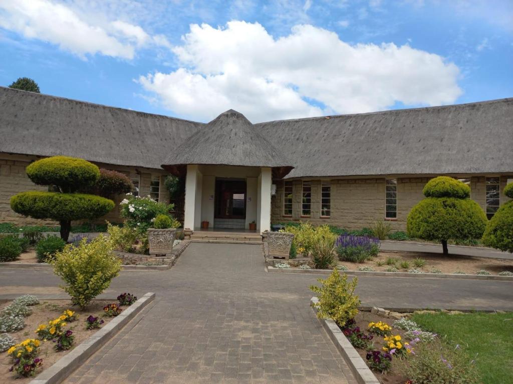 un bâtiment avec un grand toit et une cour dans l'établissement Mmelesi Lodge, à Maseru