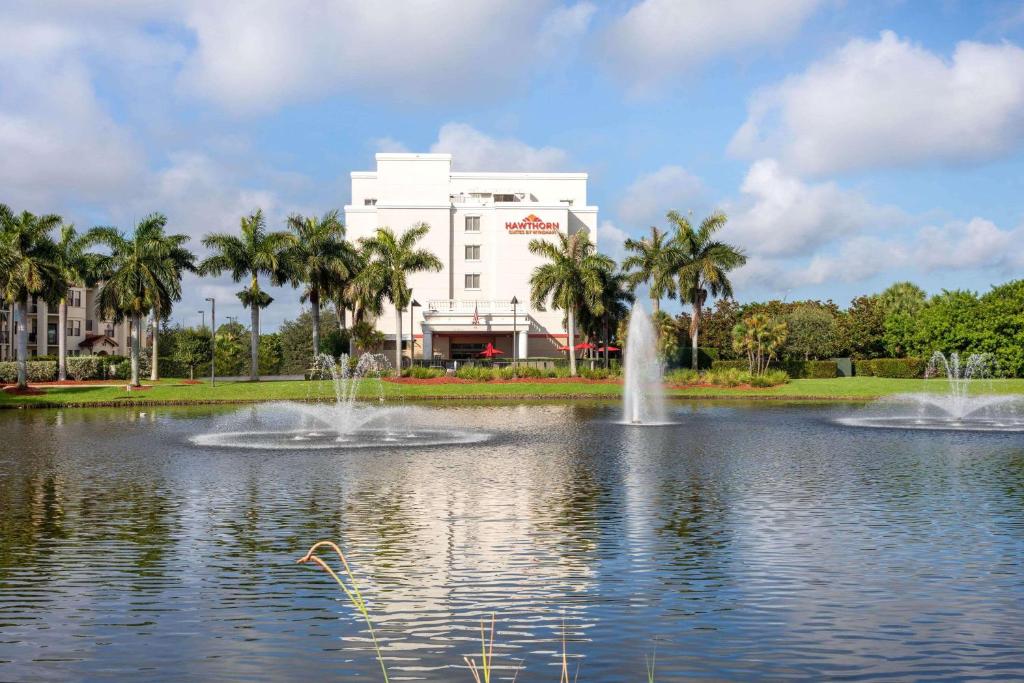 um lago com duas fontes em frente a um edifício em Hawthorn Suites by Wyndham West Palm Beach em West Palm Beach