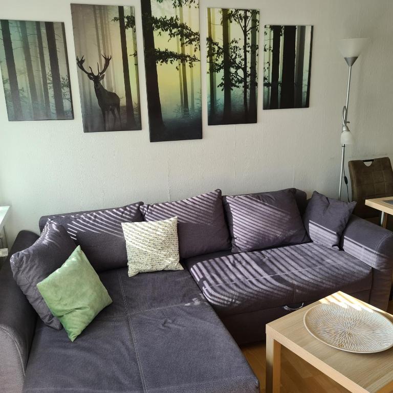 a living room with a purple couch and pictures on the wall at Appartement 7 101 in Goslar