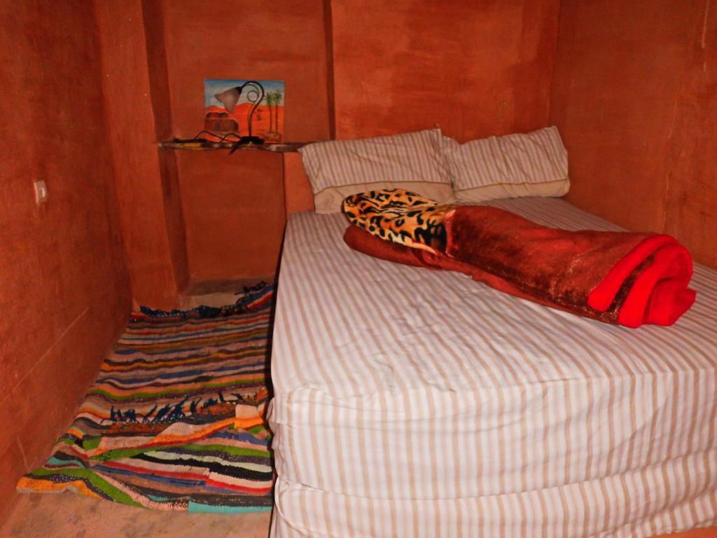 a bed with a comforter on it with at Dar Lhor in Tarhjicht