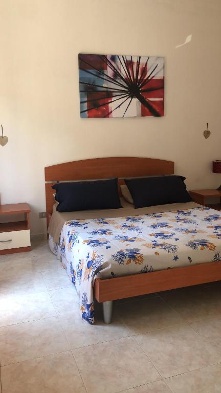 una camera da letto con un letto e un dipinto sul muro di La Rosa Dei Venti a Villa San Giovanni