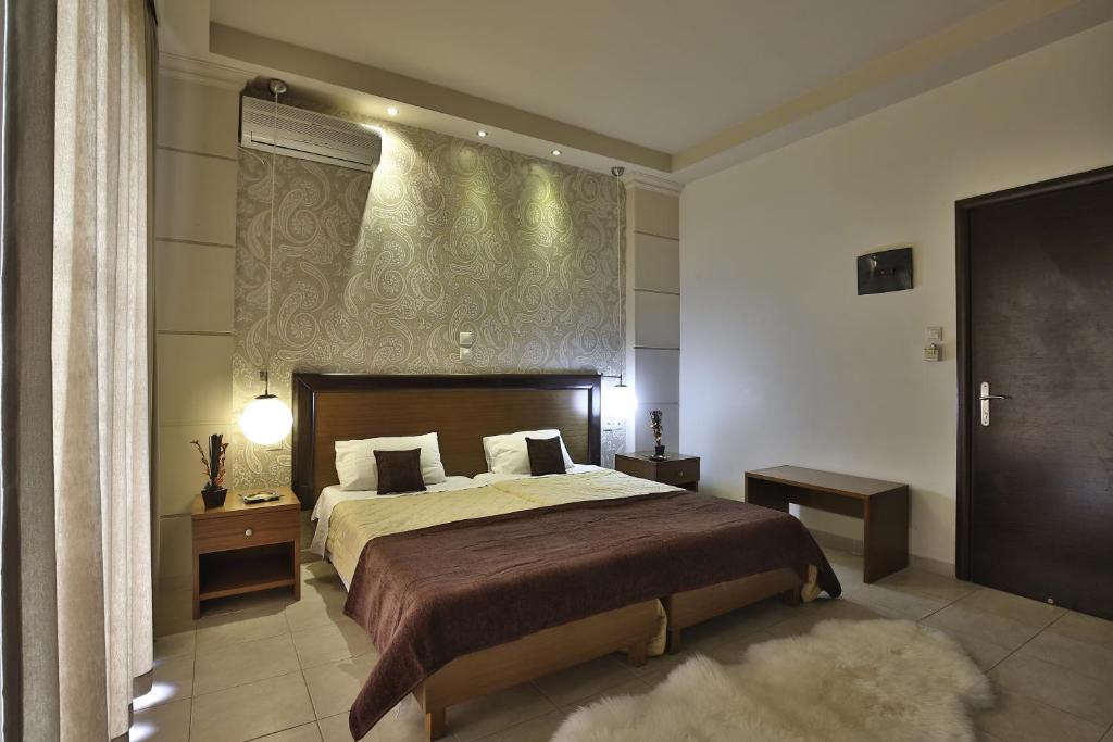Un dormitorio con una cama grande y una ventana en Saint Amon Hotel, en Faliraki
