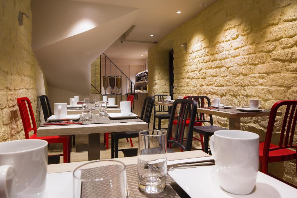 a restaurant with tables and chairs and a stone wall at Best Western Quartier Latin Pantheon in Paris