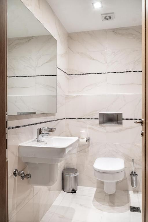 a white bathroom with a sink and a toilet at Danai Hotel & Spa in Olympic Beach