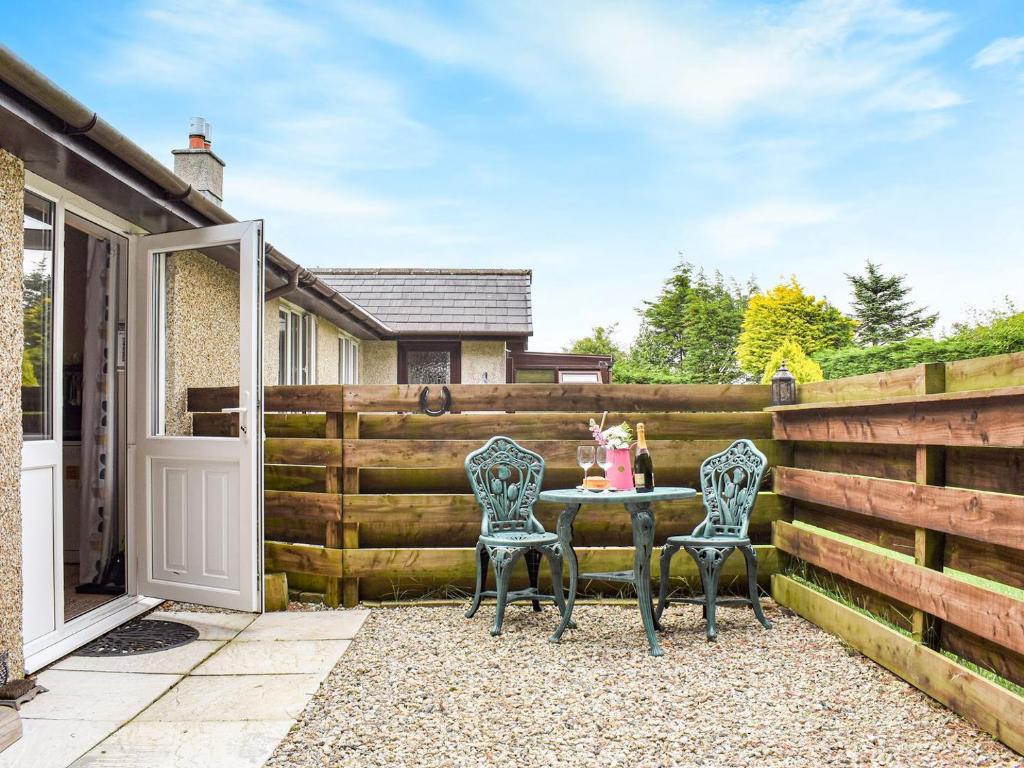un patio con 2 sillas y una mesa frente a una valla en Little Fern en Sourton