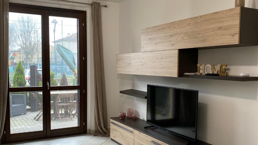 un soggiorno con TV a schermo piatto e finestra di Casa alle porte di Pavia a Pavia