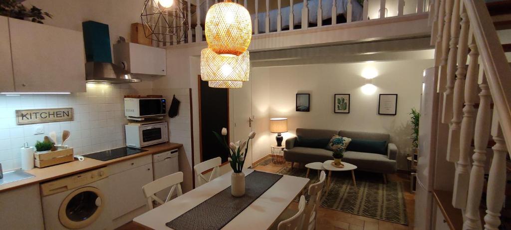 a kitchen and a living room with a table and a couch at Chill Out Cabanon Coeur Calanques in Marseille