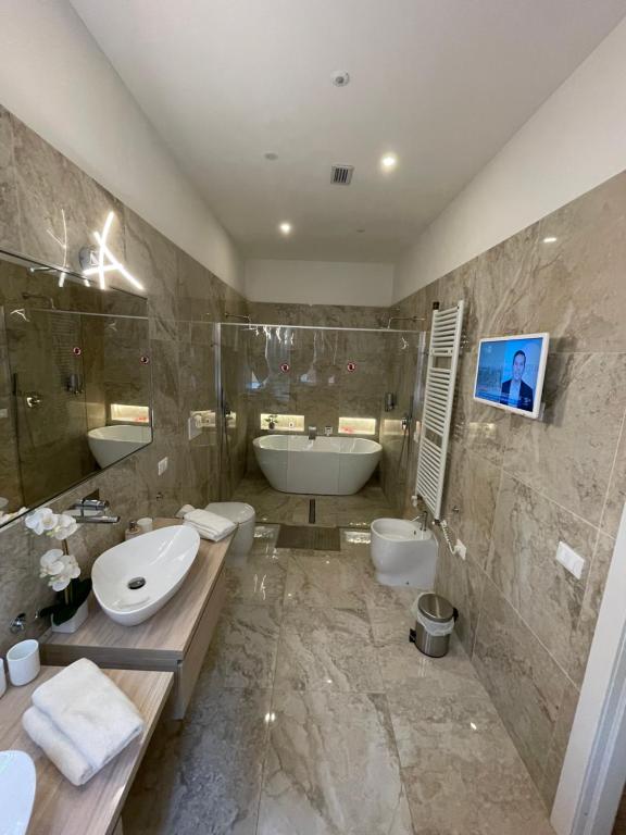 a bathroom with a tub and a sink and a tub at Luxury 3 al duomo di parma in Parma