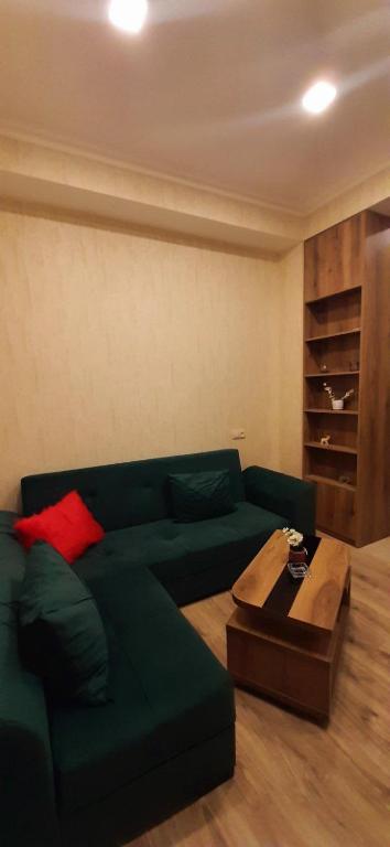 - un salon avec un canapé vert et une table en bois dans l'établissement Apartment in Tbilisi, à Tbilissi