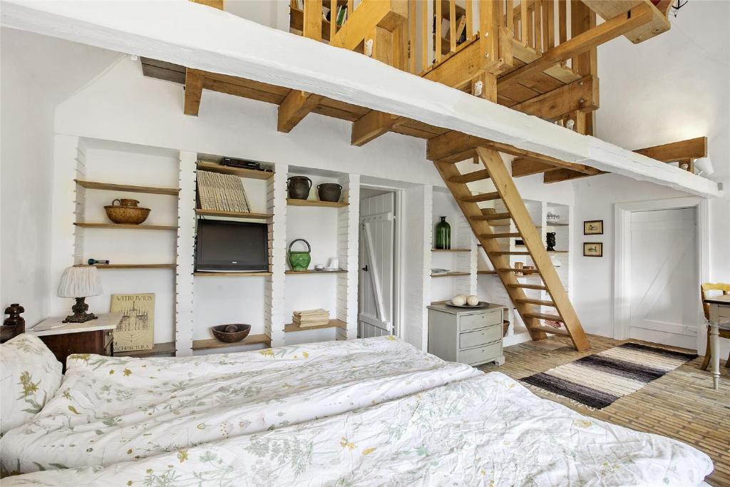 una camera da letto con un letto grande e una scala di Lillemøllens bed & breakfast a Ørbæk