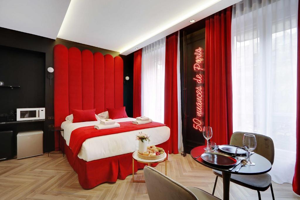 Couples Getaway Unit with Jacuzzi - City Center في باريس: غرفة نوم بسرير احمر مع طاولة وكراسي